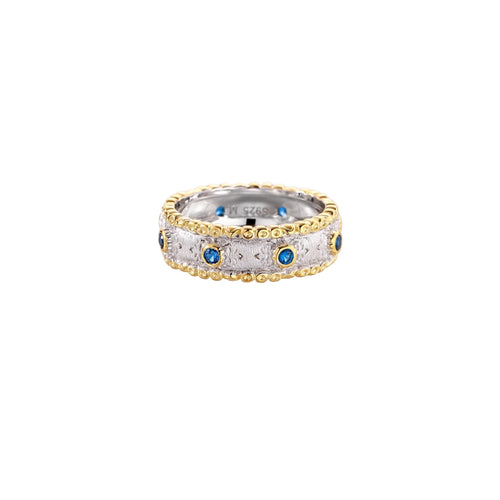 Two-tone ring with brushed silver center, gold beaded edges, and blue zirconia stones on white background.